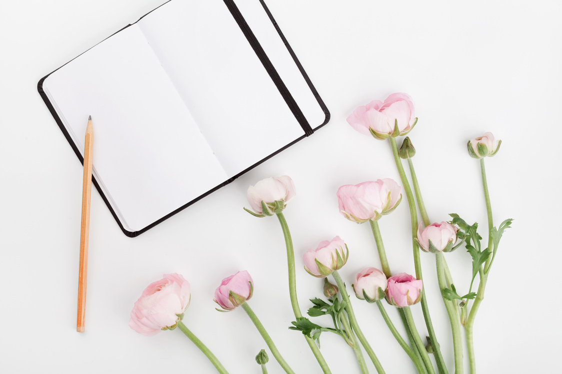 Womans working desk with flowers. Flat lay. Planning concept.